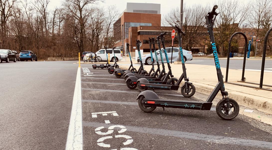 Veo e-scooters parked in a designated e-scooter parking area on campus.